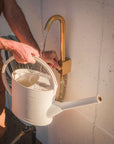 Brass outdoor water faucet filling watering can