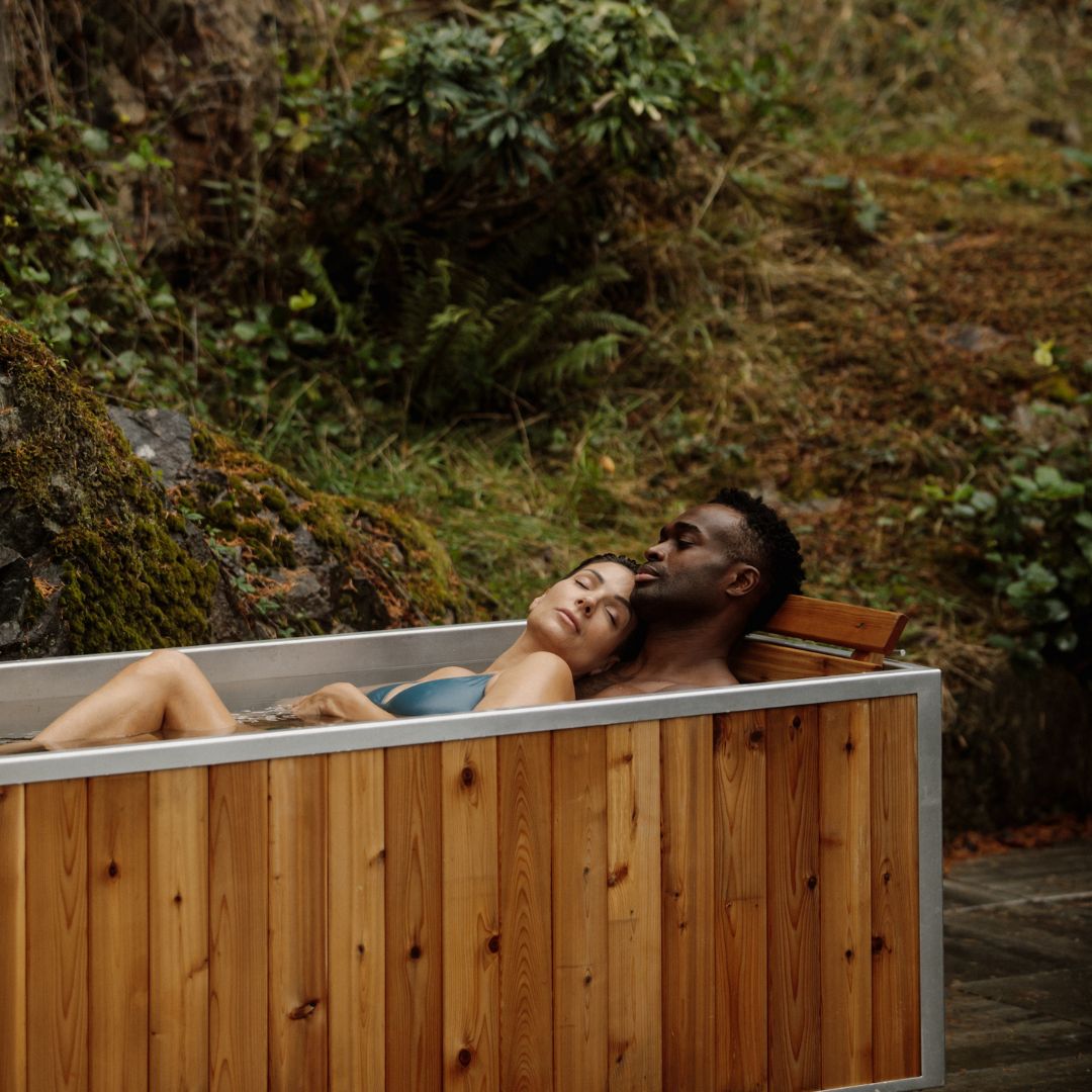 two people in hot tub lounging on cedar recliner