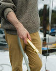 Brass spray nozzle on green garden hose