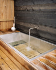 Stainless steel soaking tub with red cedar built into outdoor space