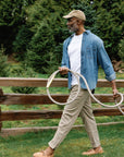 Man walking and holding a long grey garden hose from Goodland