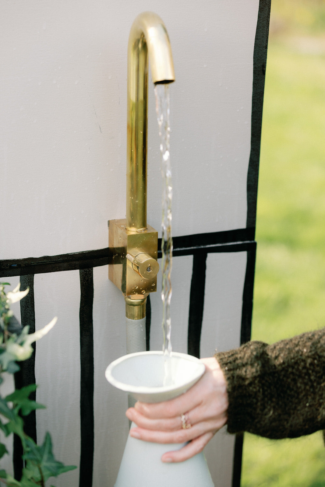brass outdoor water faucet mounted to wall