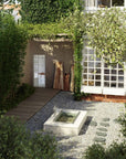 drop in tub outdoors surrounded by stone in a courtyard
