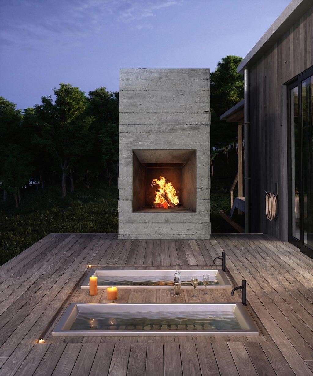 two drop in soaking tubs with faucets by an outdoor fireplace