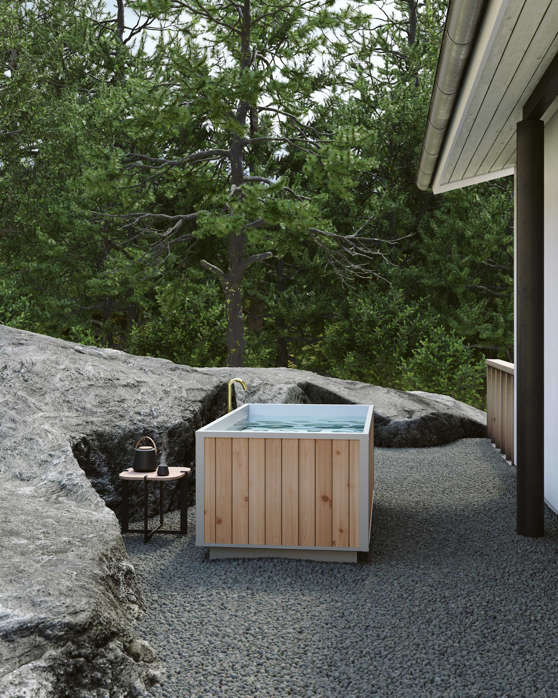 outdoor tub set on pea gravel between a house and a boulder
