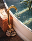 Brass faucet filling small pool outdoors