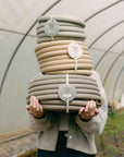 Woman holding coiled made in Canada garden hoses