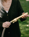 Brass shut off valve and nozzle for garden hoses with adjustable spray