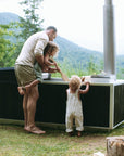 Goodland hot tub in black - dad and kids mixing the water 