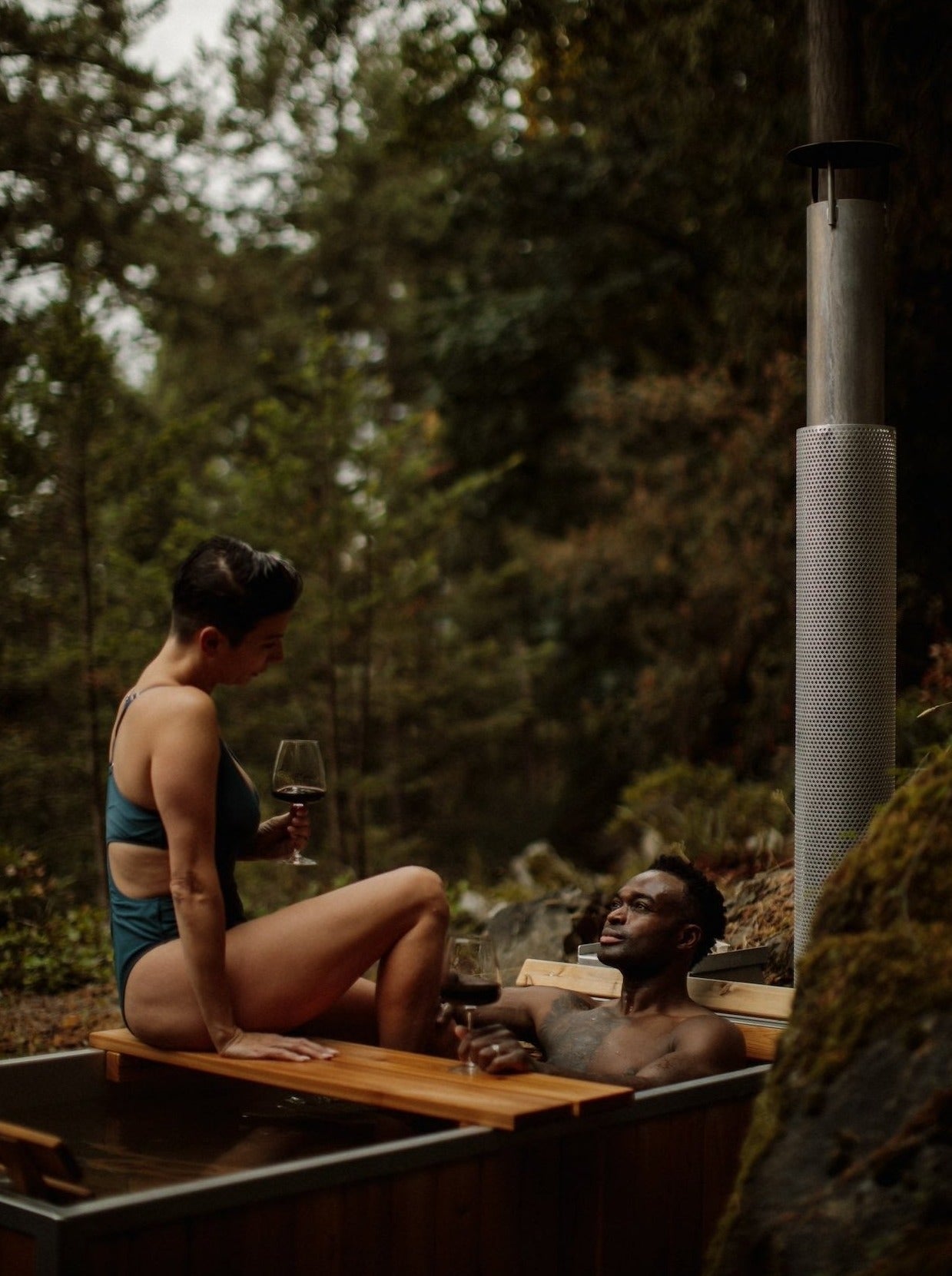 black wood fired hot tub with 2 people