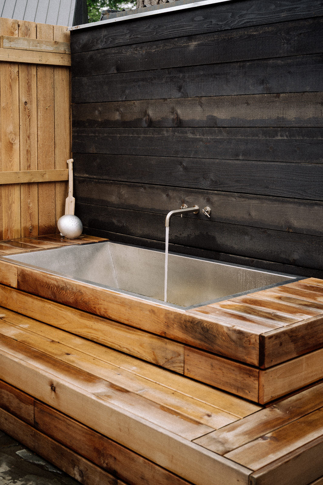 Outdoor soaking tub built in wood deck with stainless steel liner