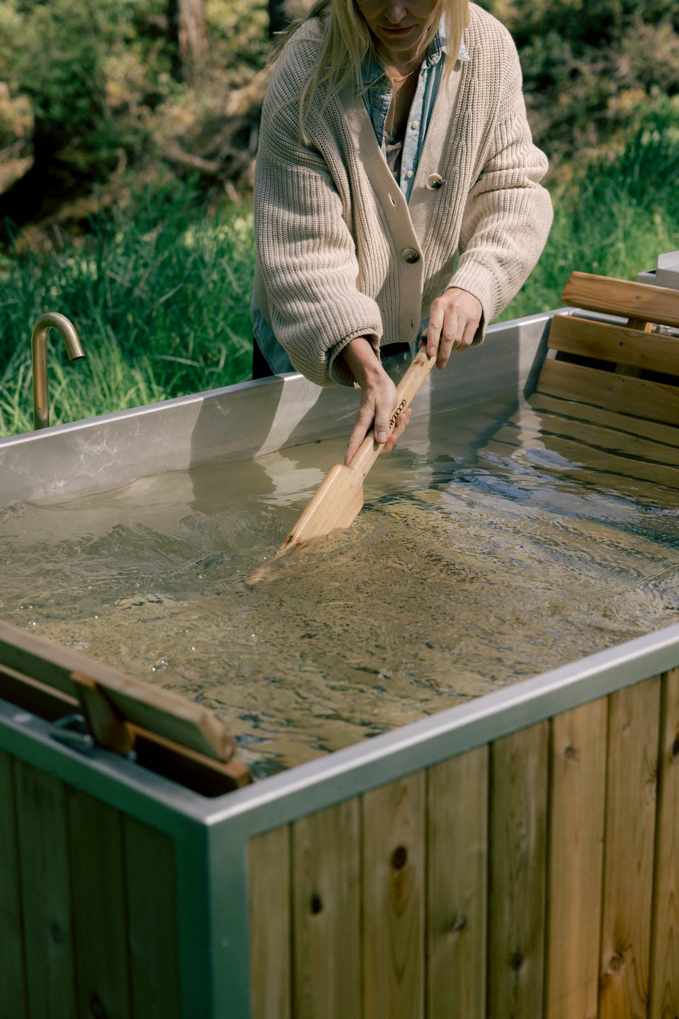 aluminum lined wood burning hot tub - stirring tub water 