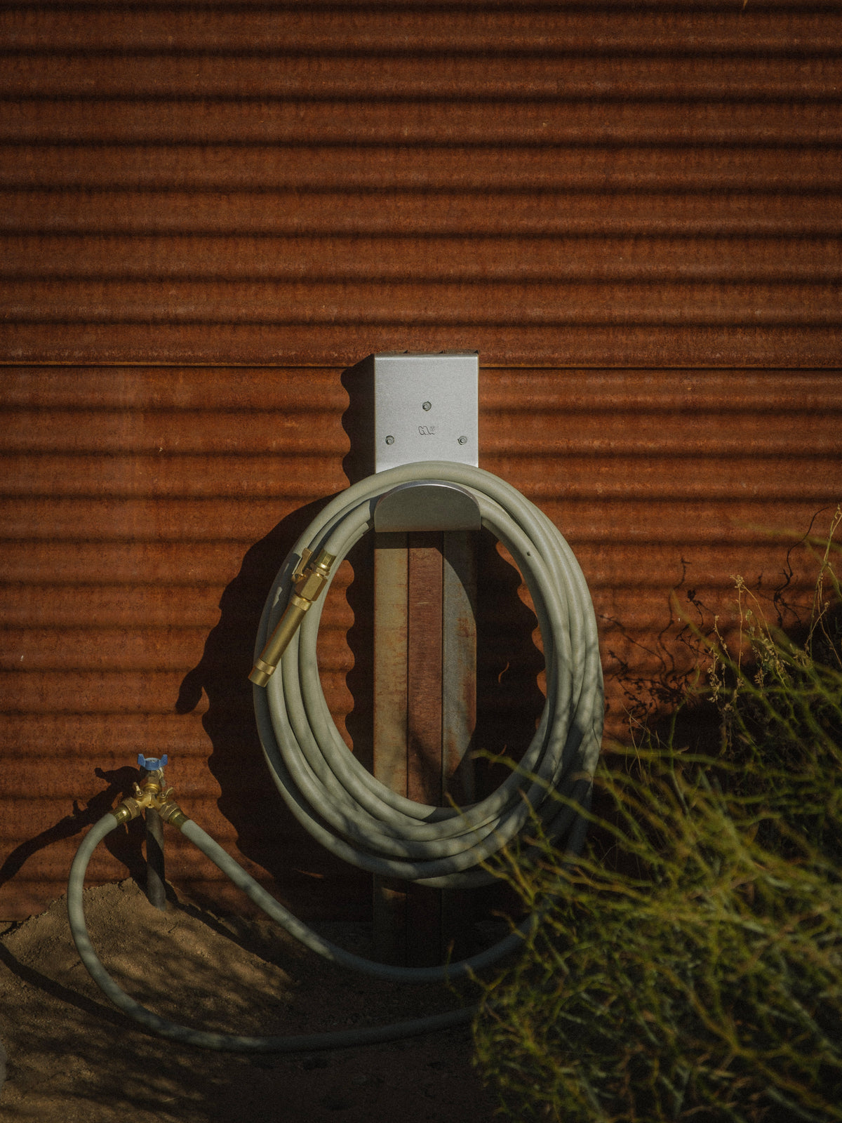 Luxury green garden hose with brass fittings that's made in Canada on wall mounted hose hanger