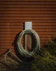 Luxury green garden hose with brass fittings that's made in Canada on wall mounted hose hanger