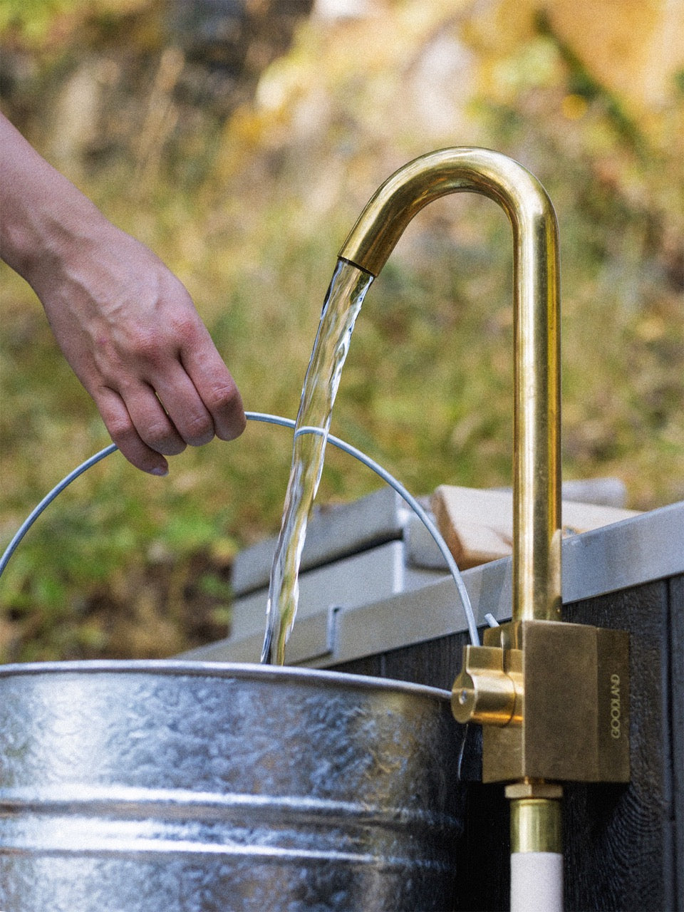 brass outdoor faucet filling a bucket