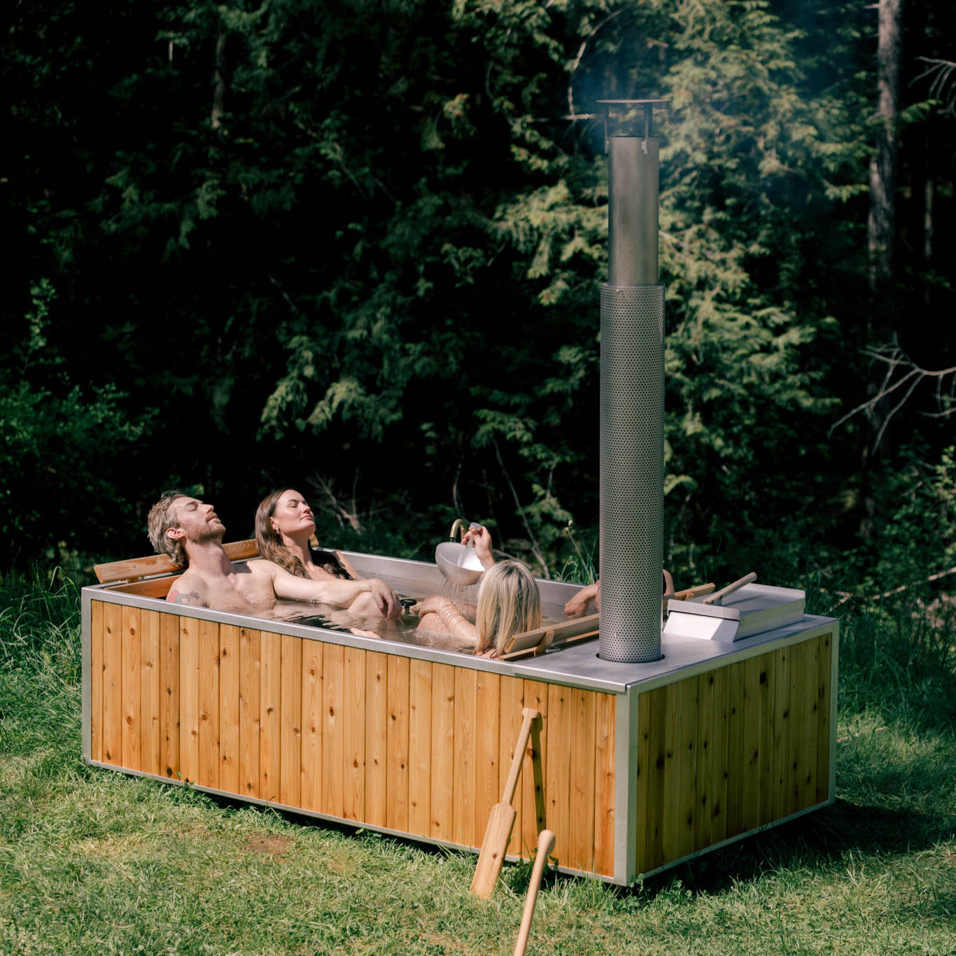 large wood fired hot tub with 4 adults soaking