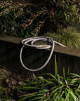 High quality grey hose coiled in garden with brass fittings