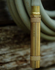 Brass garden hose spray nozzle attached to green garden hose