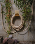 Wall mount hose holder in brass with water hose in garden 