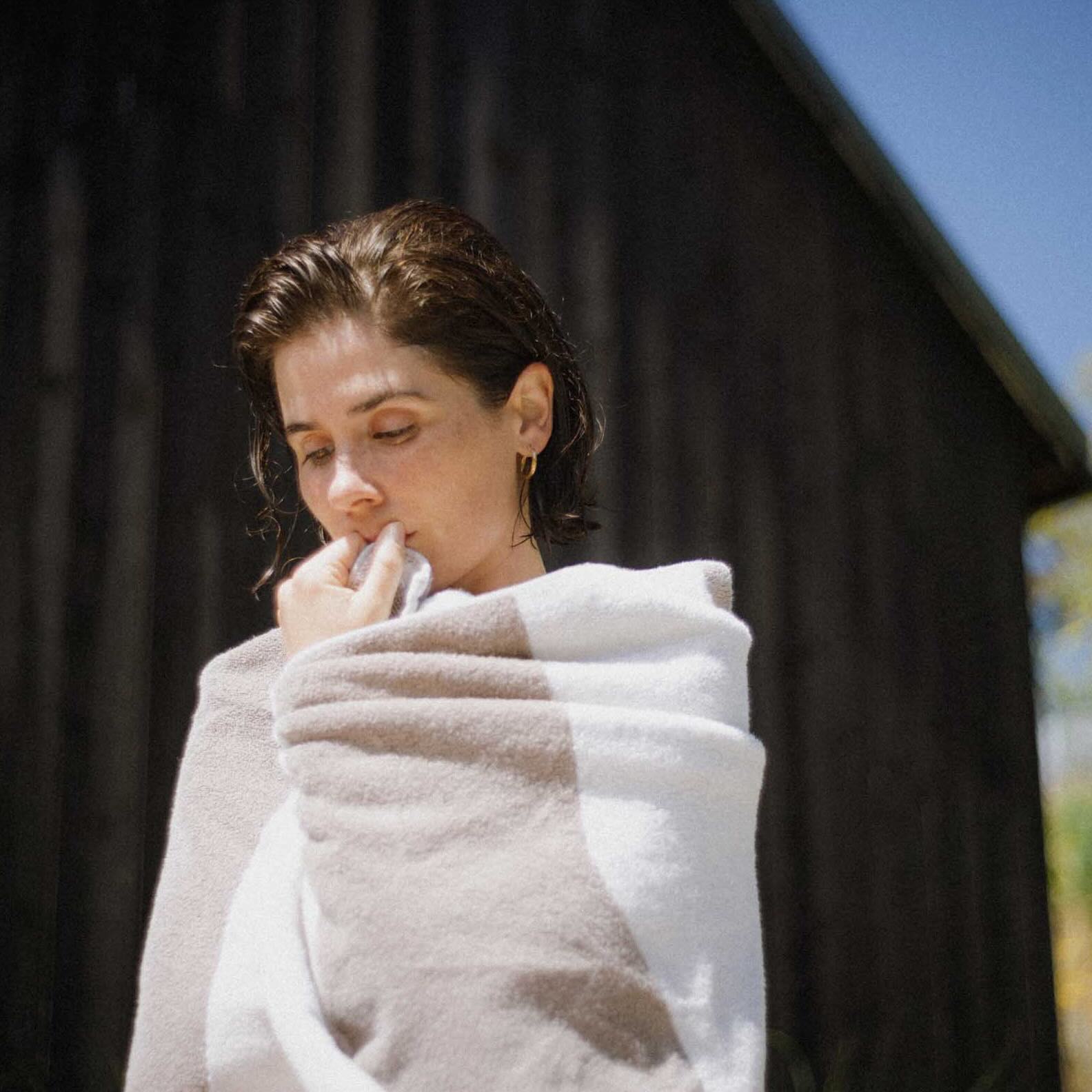 woman wrapped in a towel after bathing outside